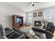 Cozy living room with a fireplace, ceiling fan, plush leather sofas and bright windows at 12610 Broadmoor N Ct, Fishers, IN 46037