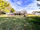Spacious backyard featuring a deck, playground, and lush green lawn at 12930 River Grove Dr, Columbus, IN 47203