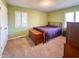 Cozy bedroom with neutral carpet, green walls, and bright windows providing ample natural light at 12930 River Grove Dr, Columbus, IN 47203