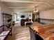 Open-concept living room with fireplace, wood floors, ceiling beams, stairs, and dining area at 12930 River Grove Dr, Columbus, IN 47203