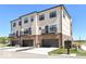 Three-story townhouses with drive-in garages and second story patios on a clear day at 12974 Pettigru Dr, Carmel, IN 46032