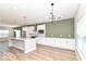 Modern kitchen with island, sleek white cabinets, stainless appliances, and wood floors at 12974 Pettigru Dr, Carmel, IN 46032
