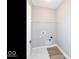 Functional laundry room with wood-look flooring, overhead shelving, and essential hookups ready for appliances at 12974 Pettigru Dr, Carmel, IN 46032