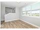 Bright living room with wood-look floors, large windows, and neutral paint at 12974 Pettigru Dr, Carmel, IN 46032