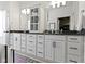 Bathroom boasts double vanities, sleek white cabinetry, and black hardware at 13071 Pennington Rd, Fishers, IN 46037