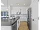 Bright kitchen featuring white cabinets, black countertops, stainless steel appliances, and hardwood flooring at 13071 Pennington Rd, Fishers, IN 46037
