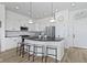 Bright kitchen features white cabinets, black countertops, a center island with seating, and stainless steel appliances at 13071 Pennington Rd, Fishers, IN 46037