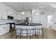 Bright kitchen features white cabinets, black countertops, a center island with seating, and stainless steel appliances at 13071 Pennington Rd, Fishers, IN 46037