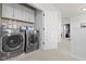 Convenient upstairs laundry room with cabinets, shelving, stainless steel washer and dryer, and neutral paint at 13071 Pennington Rd, Fishers, IN 46037