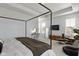 Bright main bedroom features a four-poster bed, sitting area, and neutral decor at 13071 Pennington Rd, Fishers, IN 46037