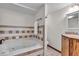 Bathroom featuring a corner soaking tub and neutral colored tile backsplash at 140 E 44Th St, Indianapolis, IN 46205