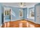 Bedroom featuring wood floors, natural light, and an adjoining sunroom at 140 E 44Th St, Indianapolis, IN 46205