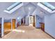 Large, carpeted bonus room with skylights, built-in storage, and neutral paint at 140 E 44Th St, Indianapolis, IN 46205