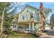 Charming two-story home with a gambrel roof, inviting front porch with swing, and brick chimney at 140 E 44Th St, Indianapolis, IN 46205