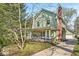 Charming two-story home with a gambrel roof, inviting front porch with swing, and brick chimney at 140 E 44Th St, Indianapolis, IN 46205