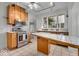 Kitchen featuring tile floors, wood cabinets, stainless oven, and breakfast nook at 140 E 44Th St, Indianapolis, IN 46205
