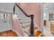 Staircase with hardwood steps, white spindles, and pink walls at 140 E 44Th St, Indianapolis, IN 46205