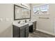 Bathroom featuring double vanities, a framed mirror, and wood-look flooring at 14234 Community Dr, Carmel, IN 46033