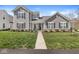 Inviting two-story home features a covered front porch, manicured lawn, and charming landscaping for great curb appeal at 14234 Community Dr, Carmel, IN 46033