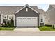 Attached two-car garage offers convenience and additional storage space with a well-maintained lawn and tidy landscaping at 14234 Community Dr, Carmel, IN 46033