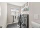 Laundry room with modern washer and dryer units, tile flooring, and ample storage space at 14234 Community Dr, Carmel, IN 46033