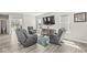 Inviting living room featuring three gray recliners, a colorful rug, and plenty of natural light at 14234 Community Dr, Carmel, IN 46033