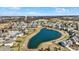 Aerial view of a neighborhood, highlighting a serene pond surrounded by well-maintained homes at 14347 Camelot House Way, Fishers, IN 46037