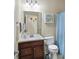 Bathroom features a vanity with a sink and a toilet adjacent to a shower with a blue curtain at 14347 Camelot House Way, Fishers, IN 46037