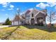 Beautiful two-story home with brick and stone exterior, manicured lawn, and mature trees at 14347 Camelot House Way, Fishers, IN 46037