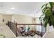 Hallway with wrought iron railing with a view of the dining room below at 14347 Camelot House Way, Fishers, IN 46037