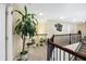 Hallway with dark wood banister, stained glass and a variety of potted plants at 14347 Camelot House Way, Fishers, IN 46037