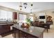 Open kitchen with granite countertops, a large island, and seamless flow into the dining area at 14347 Camelot House Way, Fishers, IN 46037