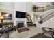 Open-concept living room with a fireplace, TV, and staircase leading to an upper floor at 14347 Camelot House Way, Fishers, IN 46037