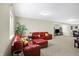 Spacious living room featuring a comfortable red leather sofa and neutral-toned walls at 14347 Camelot House Way, Fishers, IN 46037