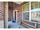 Inviting porch features brick accents, a cozy bench, and charming outdoor decor at 14347 Camelot House Way, Fishers, IN 46037