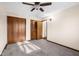 Cozy bedroom features plush carpeting, a ceiling fan, and closet space for ample storage solutions at 15620 E State Road 46, Columbus, IN 47203