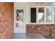 Close-up of the front porch entrance featuring a decorated front door with a bay window at 15620 E State Road 46, Columbus, IN 47203