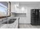 Bright kitchen featuring a stainless steel sink, granite countertops, and black stainless refrigerator at 15620 E State Road 46, Columbus, IN 47203