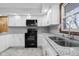 Modern kitchen featuring granite countertops, white cabinets, and a stainless steel sink at 15620 E State Road 46, Columbus, IN 47203