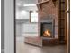 Cozy living room showcasing a brick fireplace and an open view into the renovated kitchen at 15620 E State Road 46, Columbus, IN 47203