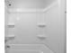 Clean white tub and shower combo with built-in shelving and chrome shower head at 15620 E State Road 46, Columbus, IN 47203