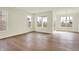 Bright, spacious living room with hardwood floors, large windows, and neutral walls at 1603 Clover Crossing Dr # 1A, Greenfield, IN 46140