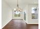 Bright dining room with a modern chandelier, wood floors, and large windows at 1609 Clover Crossing Dr, Greenfield, IN 46140