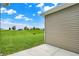 Exterior corner with vinyl siding, leading to a concrete patio, and a spacious, green lawn at 1609 Clover Crossing Dr, Greenfield, IN 46140