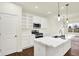 Bright kitchen featuring white cabinets, a kitchen island, modern appliances, and an adjacent living area at 1609 Clover Crossing Dr, Greenfield, IN 46140