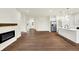 Open-concept living room featuring a fireplace, hardwood floors, and an open view to the kitchen area at 1609 Clover Crossing Dr, Greenfield, IN 46140