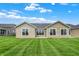 Rear exterior showcasing numerous windows and a well-kept lawn, complemented by a bright blue sky at 1609 Clover Crossing Dr, Greenfield, IN 46140