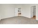 Spacious bedroom with carpet, en-suite bathroom, and open access to kitchen at 1615 Clover Crossing Dr # 2A, Greenfield, IN 46140