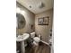 This powder room features a pedestal sink, decorative mirror, and charming artwork at 1670 Crossley St, Fortville, IN 46040