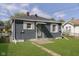 View of the property's exterior, featuring gray siding and manicured lawn at 1817 Medford Ave, Indianapolis, IN 46222